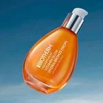 Flacone e vasetti Biotherm Aquasource+ in vetro arancione su sfondo arancione brillante, con coperchi argentati e gel idratante visibile.
